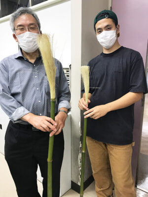 小村さん製作の完成したばかりの竹筆2本を手にした廣瀬教授(左)と小村さん(右)