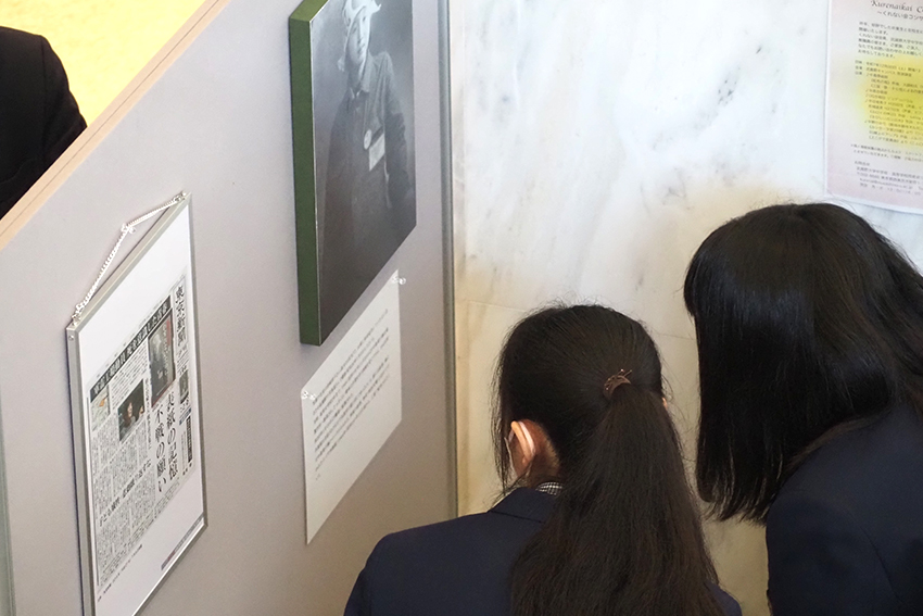 写真に添えられた文章を真剣に読む高校生